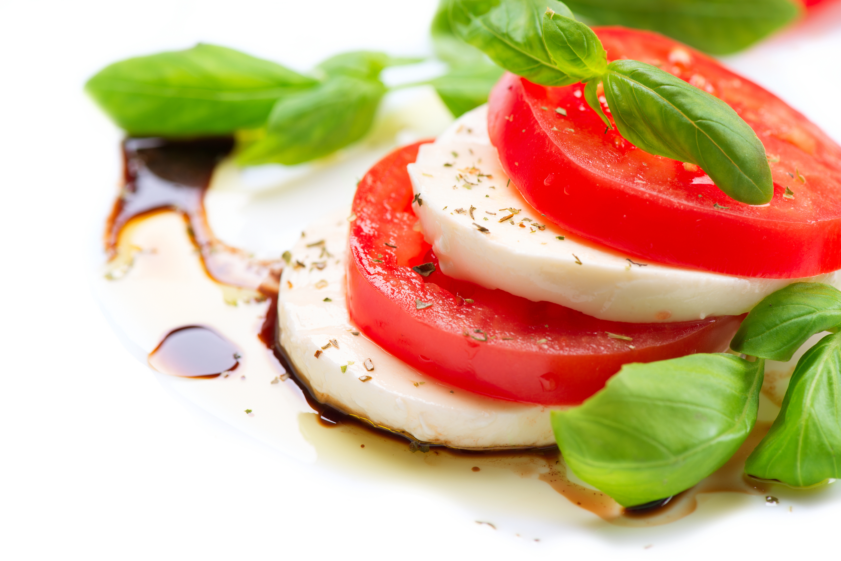 Caprese Salad. Tomato and Mozzarella slices with basil leaves. Over white background